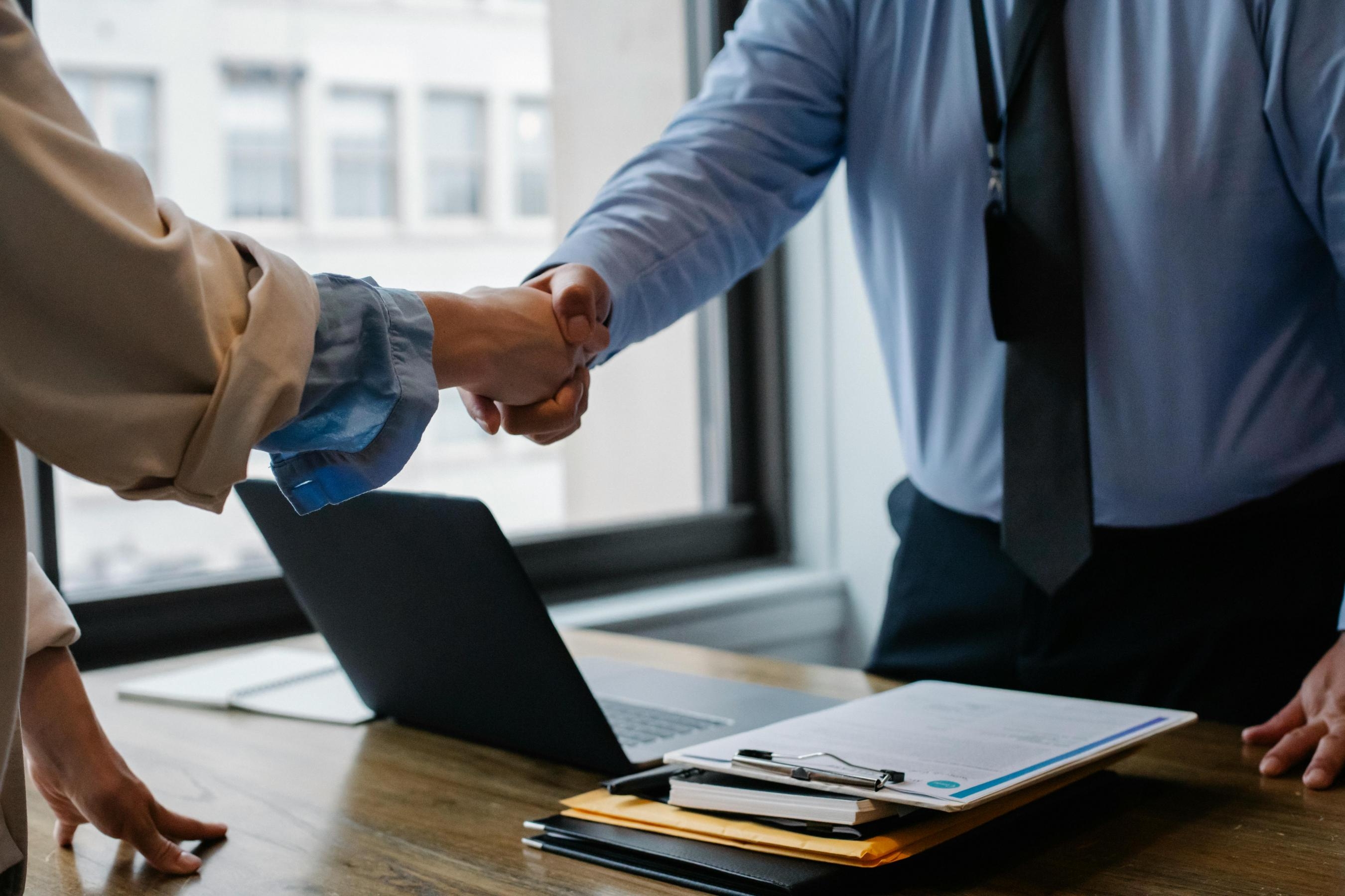 A man and a woman shaking hands in an office environment